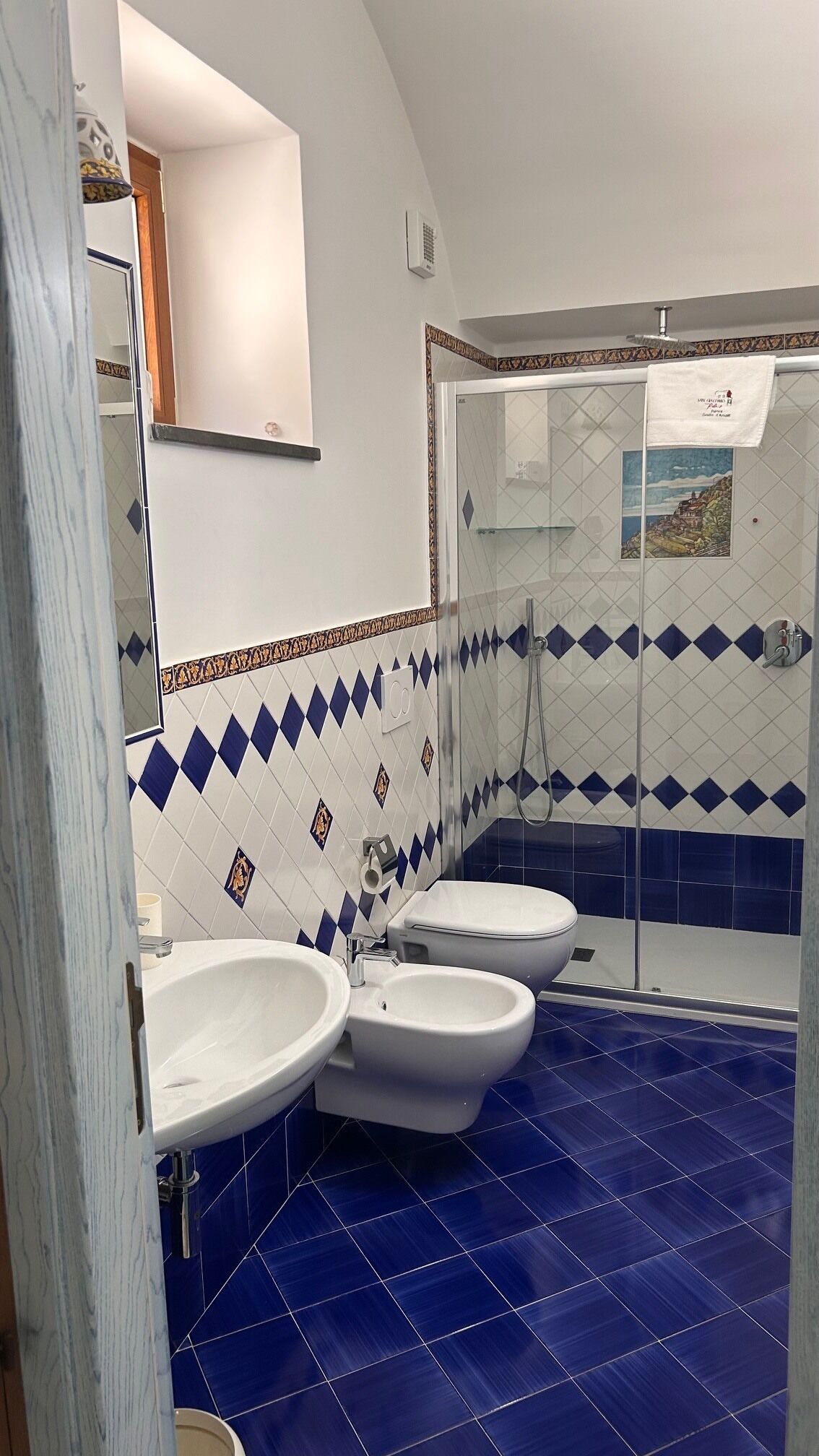 A bathroom with a shower, two sinks, and a toilet.