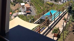 A coastal town with a view of the sea, a swimming pool, and a hillside with buildings. - San Giacomo Relais (Furore)