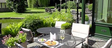 An outdoor patio with a round table, chairs, and umbrellas.
