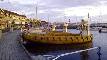 Ein hölzerner Steg mit einem gelben Boot, das in einer Marina liegt.