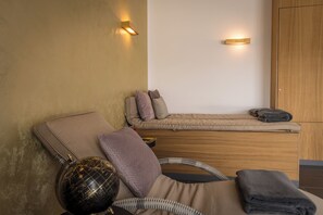 Une chambre à coucher comprenant un lit, une table de chevet, un globe terrestre et deux lampes fixées au mur.