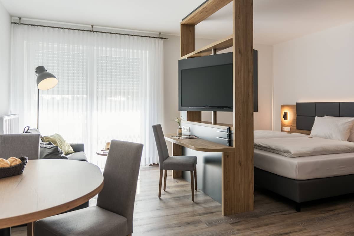 Una habitación de hotel moderna con cama, escritorio y televisor.