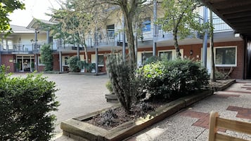 A courtyard with a reception area, a restaurant, and a covered seating area.