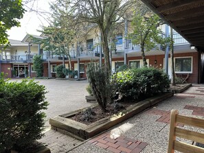 A courtyard with a reception area, a restaurant, and a covered seating area. - Waldhotel Zum Bergsee Damme (Damme)