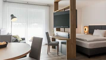 A modern hotel room with a bed, desk, and TV.