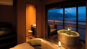 A hotel room with a bed, a small bathroom, and a balcony with a hot tub. - Jikan Wo Tabisuru Yado Umi No Hana (Atami)