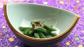 A bowl with green beans and a piece of meat on a purple patterned tablecloth. - Ryokan Aizu Yunokami Onsen Hotel Osakaya (MINAMIAIZU GUN SHIMOGO MA)