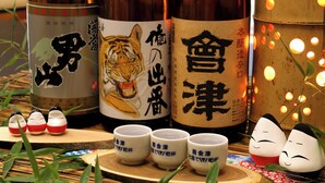 Bottles with Japanese characters and a tiger illustration, along with three ceramic cups with Japanese text. - Ryokan Aizu Yunokami Onsen Hotel Osakaya (MINAMIAIZU GUN SHIMOGO MA)