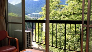 A room with a view of a bridge, a table, and a chair. - Ryokan Aizu Yunokami Onsen Hotel Osakaya (MINAMIAIZU GUN SHIMOGO MA)