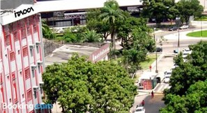 A multi-story building with a red and white facade, surrounded by greenery and a curved road. - Itaoca Belém (Belém)