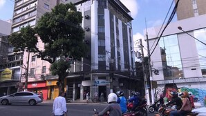 Un edificio de varios pisos con un letrero que dice 'LOTOCENTER' en la planta baja.