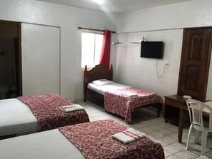 A room with two single beds, a desk, a chair, a TV, and a window with red curtains. - Itaoca Belém (Belém)