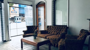 Una sala de estar con un sofá, una mesa de centro y una puerta que da al exterior.