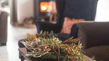 Una sala de estar acogedora con chimenea, un sofá y una mesita decorada con plantas.