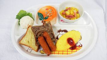 A tray with a variety of food items including bread, sausage, a boiled egg, a bowl of corn with ham, and a packaged orange drink.