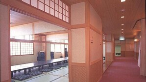 Et traditionelt japansk rum med tatamimåtter, skydedøre og et lavt bord med puder.