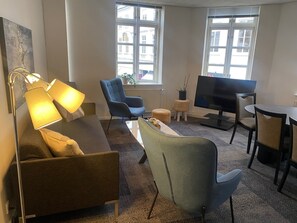 Departamento urbano, 1 cama Queen size y sofá cama, vista a la ciudad | Área de sala de estar | Televisión de pantalla plana 