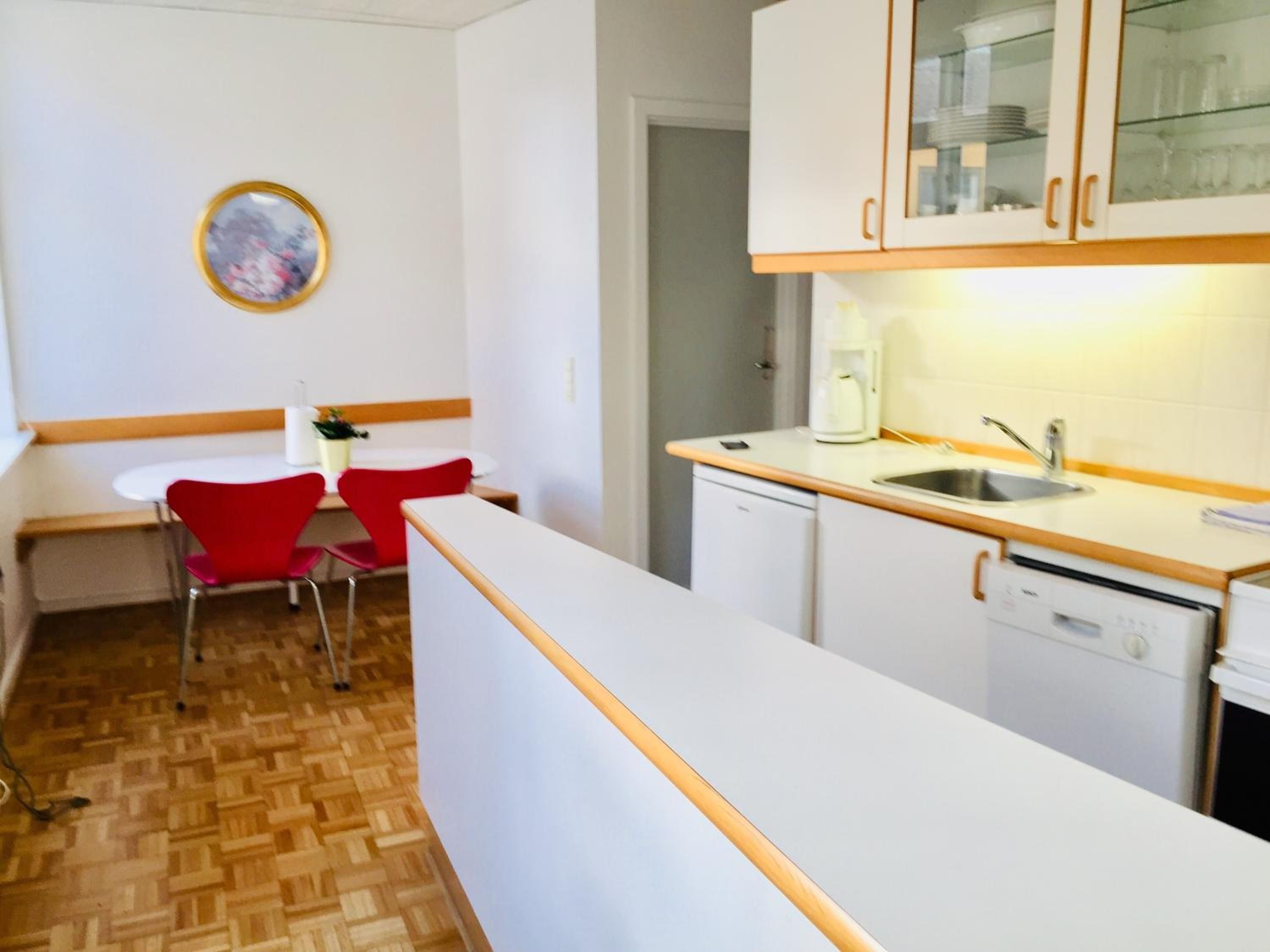 A compact kitchen with white cabinets, a wooden countertop, and a sink.