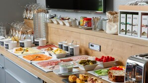 Una mesa de buffet con diversos alimentos y salsas.