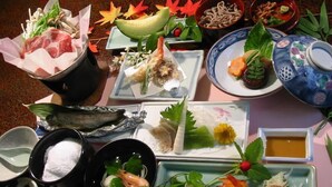 Diversos pratos e ingredientes sobre uma mesa, incluindo frutos do mar, vegetais e uma tigela de sopa.
