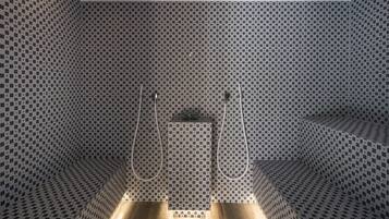 A modern bathroom with a checkered tile pattern, a central sink, and two showerheads.