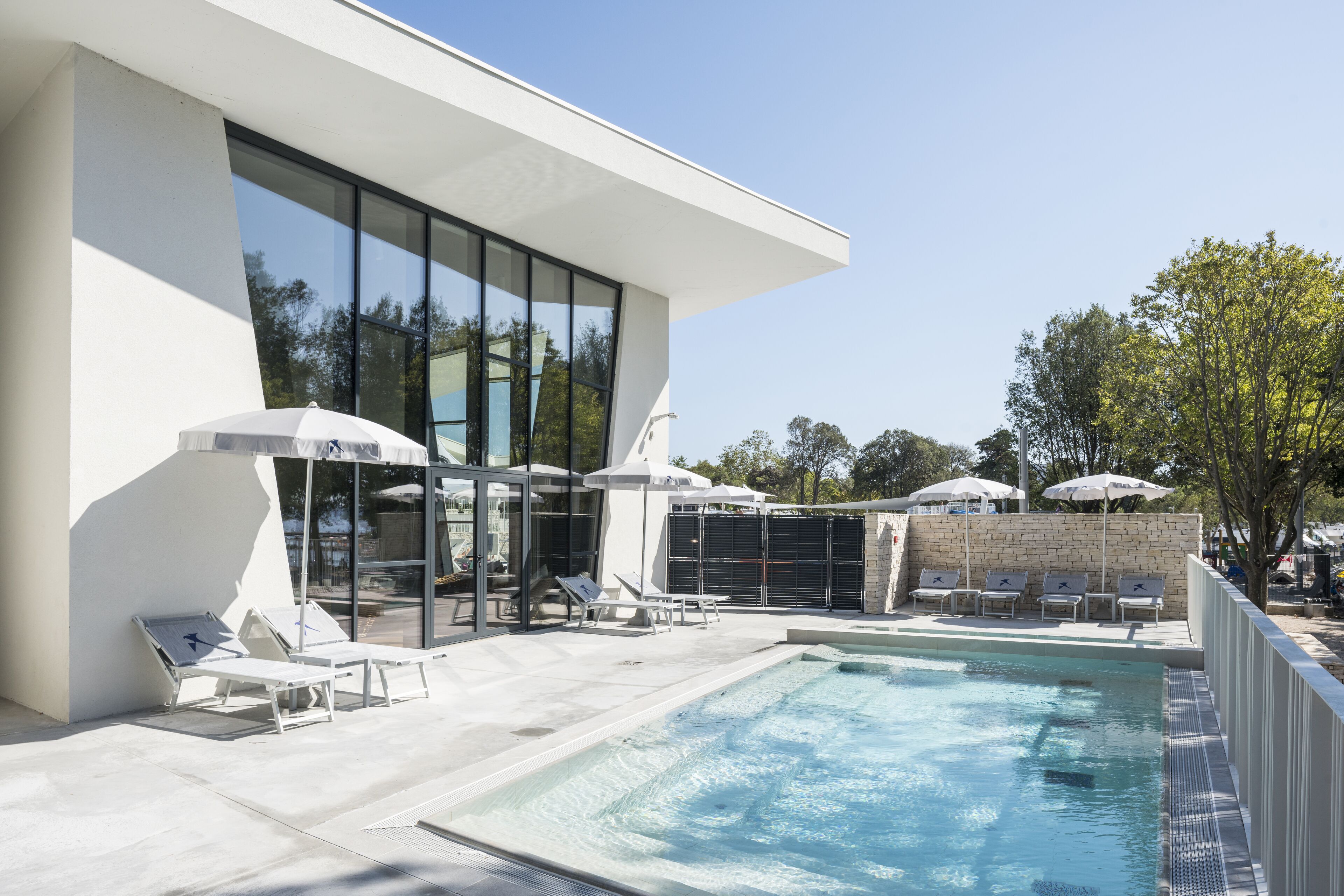 Kauden mukainen ulkouima-allas, aurinkovarjoja, aurinkotuoleja