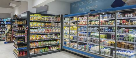 A grocery store aisle with cereal and dairy products on shelves and in refrigerated cases.