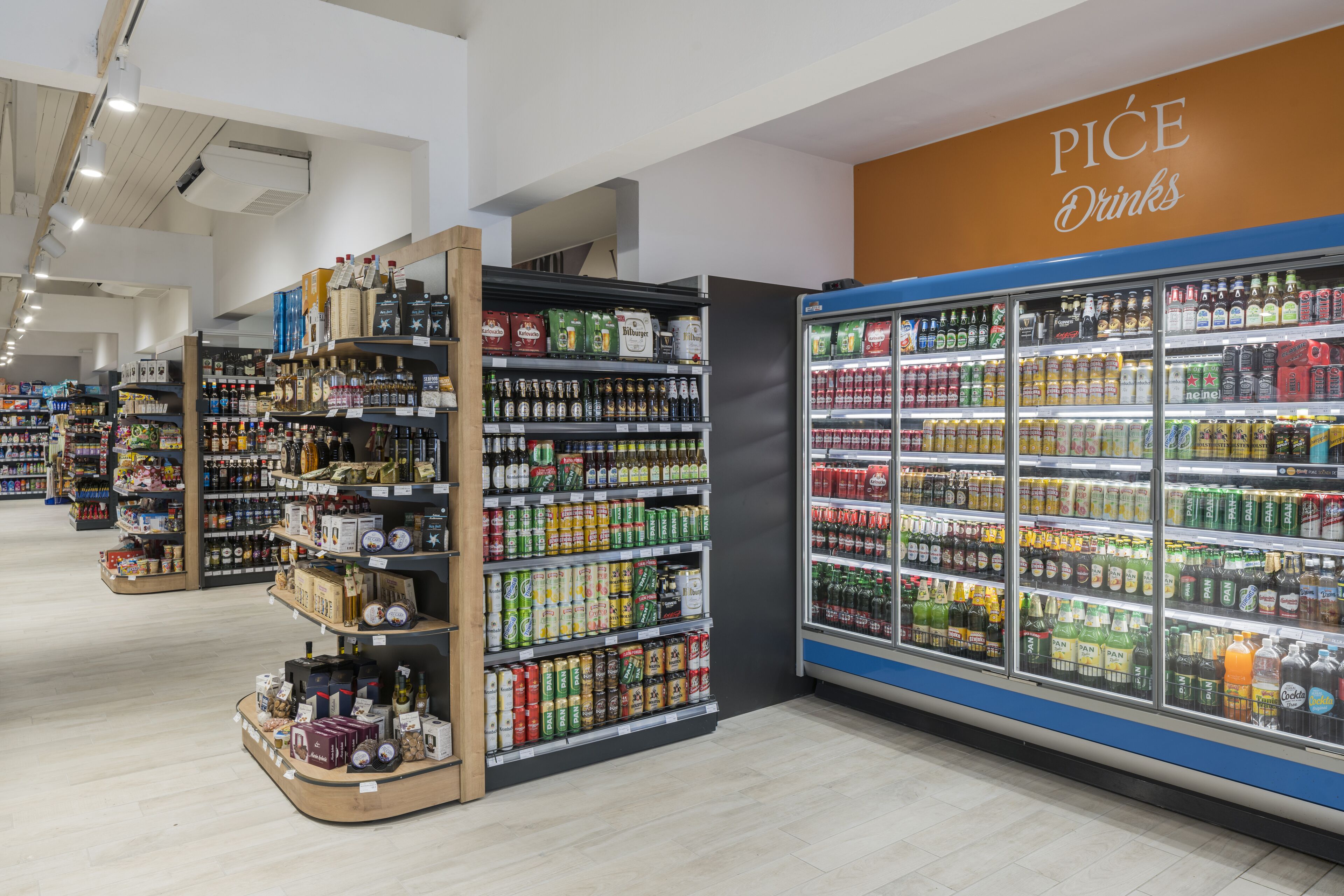 Pasillo de un supermercado con estantes llenos de bebidas y aperitivos.
