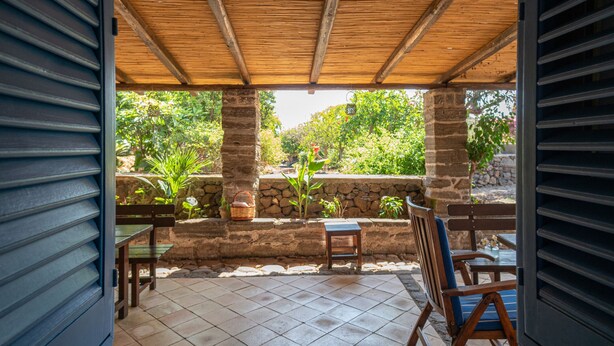 Eine offene Terrasse mit Holzboden, Steinwänden und Fliesenböden.