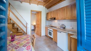 Eine Küche mit Holzausstattung, einem Herd und einem Essbereich mit Tisch und Stühlen.
