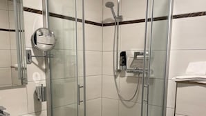 A modern bathroom with a glass-enclosed shower, a white sink, and a toilet. - Harburger HOF (Hamburg)
