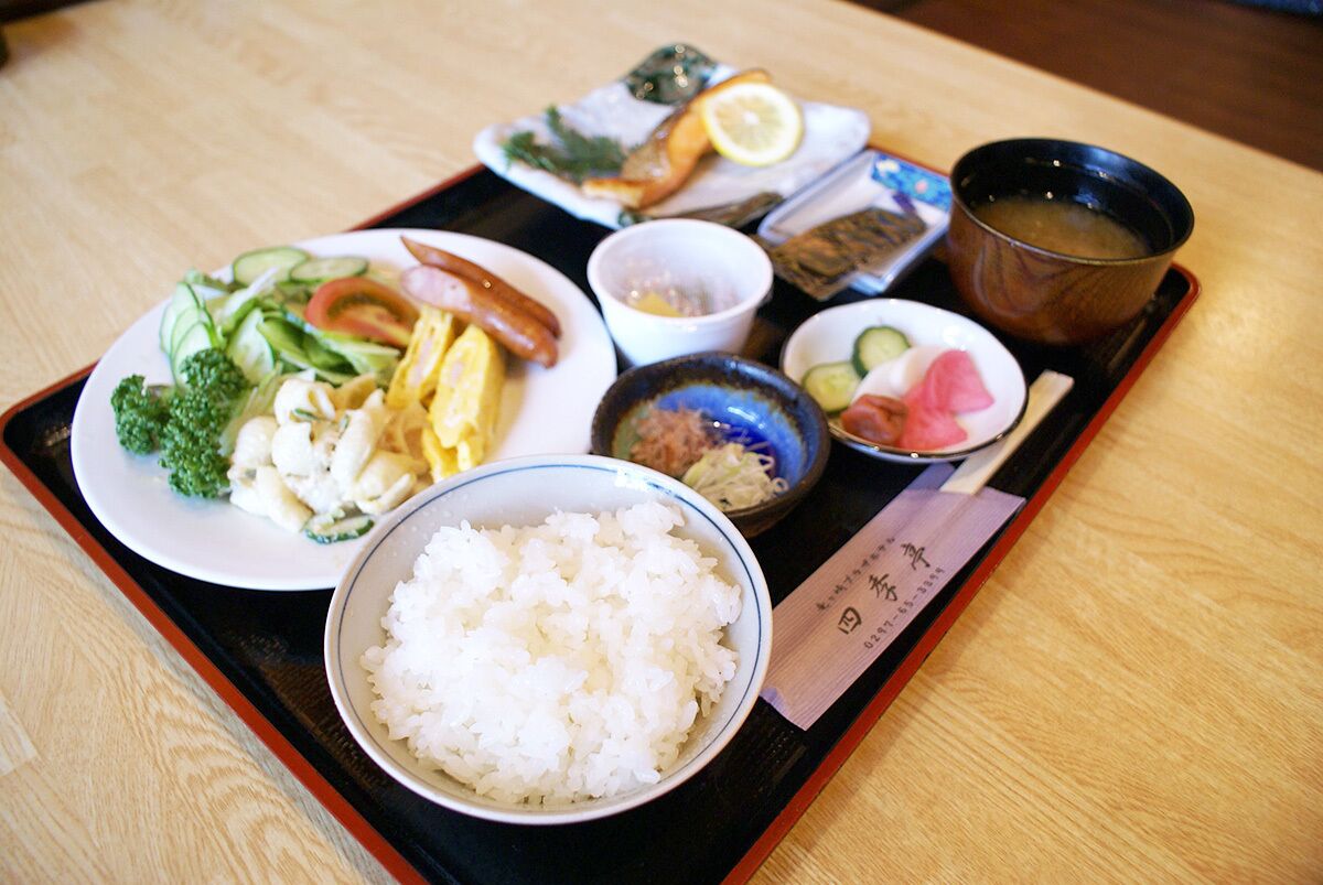 A tray with various dishes including rice, vegetables, and a bowl of soup.