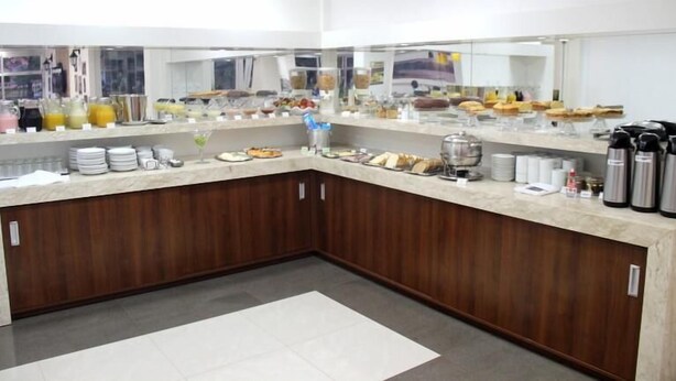 A breakfast buffet area with various food items and beverages. - Hotel Obino São Borja (São Borja)