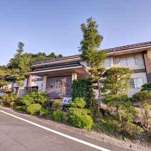 Un bâtiment de style architectural japonais traditionnel, caractérisé par une entrée imposante ornée de sculptures complexes.