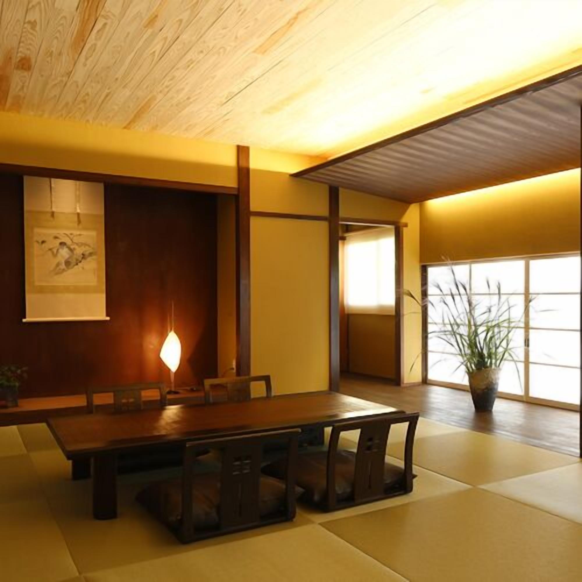 A traditional Japanese-style room with tatami flooring, a low table with cushions, and a sliding door.