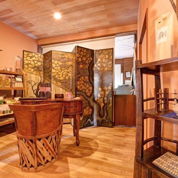 Una habitación con piso de madera, un divisor de ambiente japonés tradicional y una silla de madera.