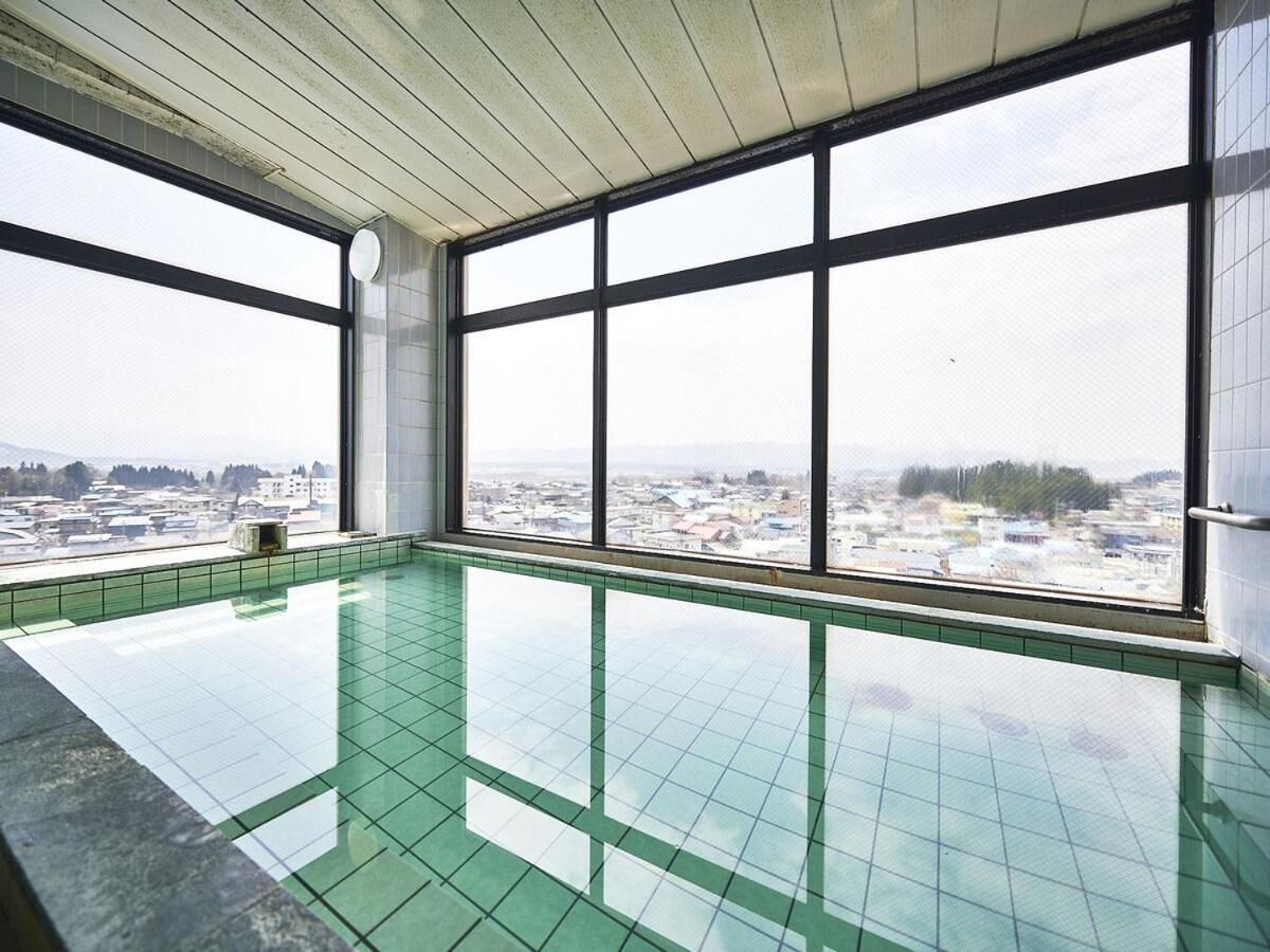 An indoor swimming pool with large windows offering a city view.
