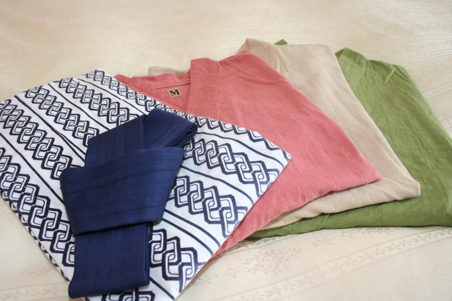 Una cama con un edredón estampado y almohadas de varios colores.