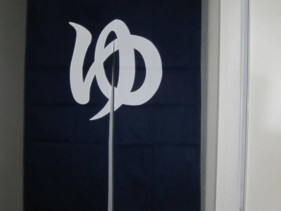 Eine dunkelblaue Wand mit einem weißen Logo und dem Wort "EMERGENCY" in weißer Schrift.