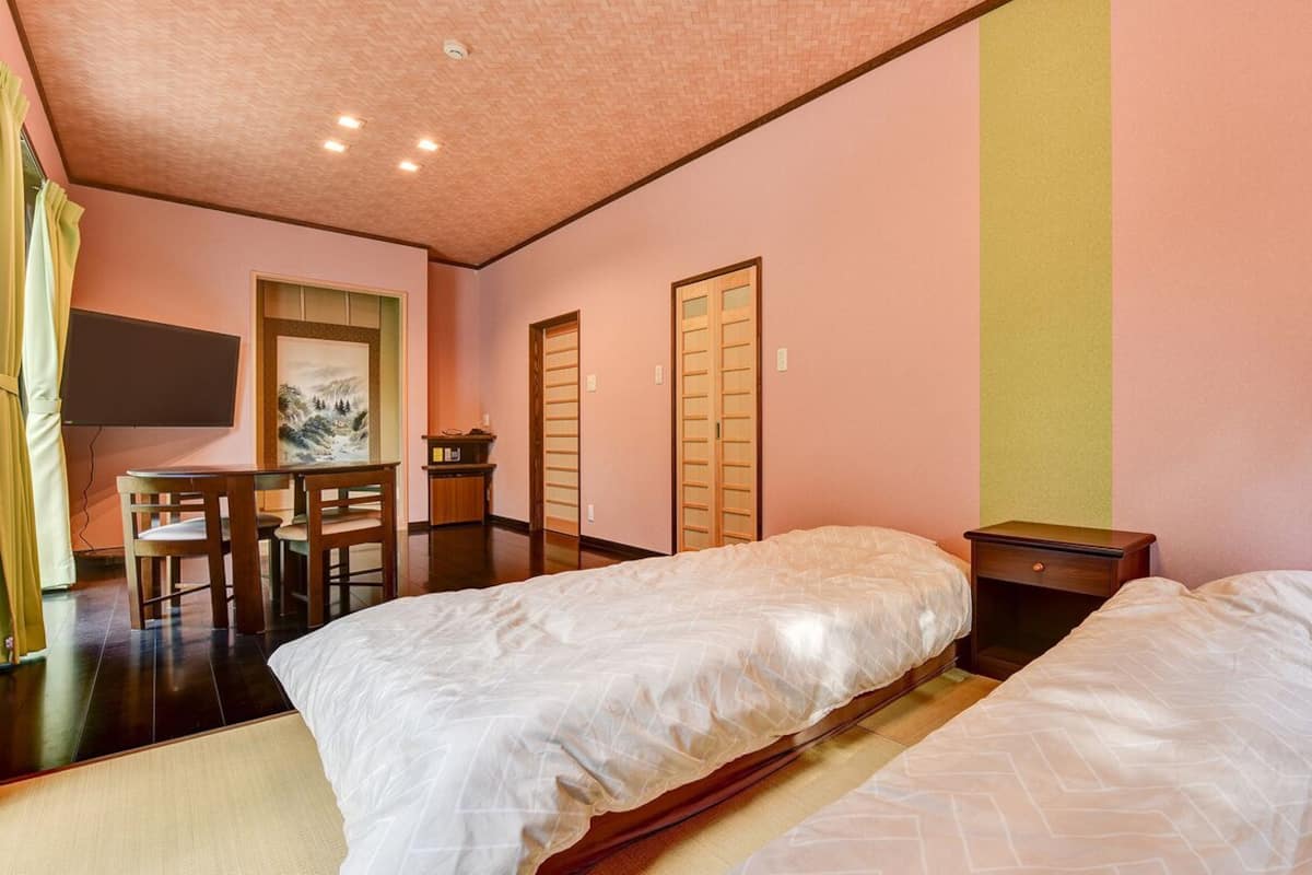 Une chambre d’hôtel avec deux lits, un bureau et des chaises.