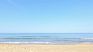 A beach with clear skies and calm water.