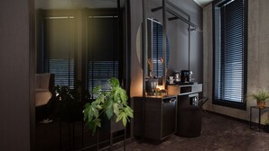 Eine moderne Küche mit dunklen Schränken, einer Kaffeemaschine und einem Blumentopf.