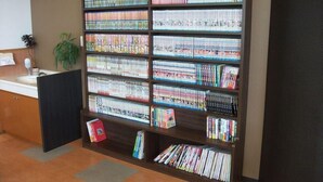 A large bookshelf filled with books and magazines in a room with a sink and a plant. - Hotel 1-2-3 Shimada (Shimada)