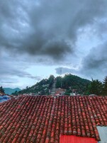 Vista de una zona montañosa con tejas de arcilla roja y un pequeño edificio de techo rojo.