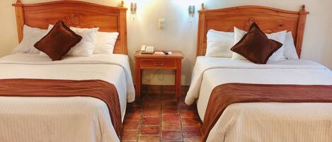 Two single beds with wooden headboards, white bedding, and brown pillows.