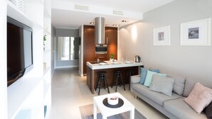 Ein modernes Wohnzimmer mit einer Couch, einem Couchtisch und einem Fernseher.
