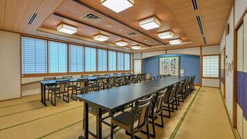 A conference room with a long table, chairs, and large windows.