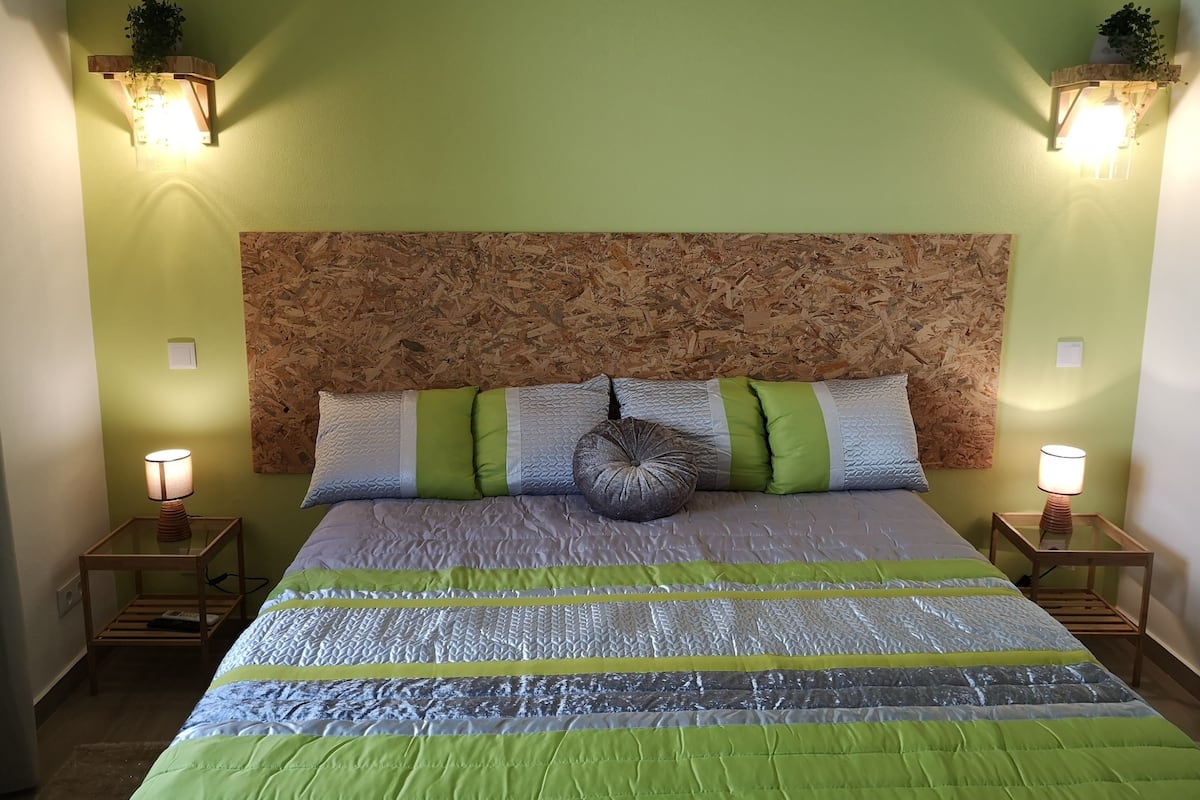 A bed with a textured headboard, multiple pillows, and bedside lamps.