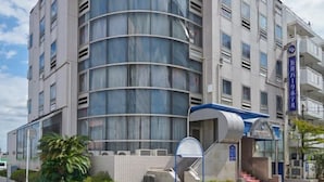 A modern hotel with a curved facade, large windows, and a covered entrance. - GOI Park Hotel (Ichihara)