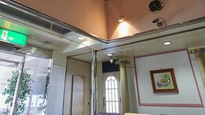 A modern interior with a high ceiling, recessed lighting, and a seating area with sofas and a coffee table. - GOI Park Hotel (Ichihara)